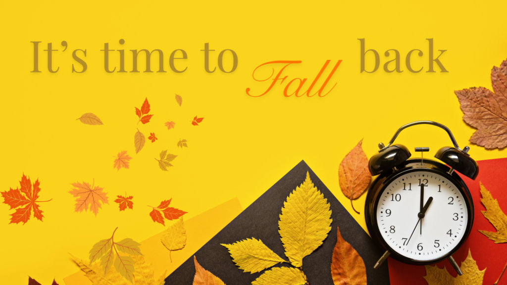 A black alarm clock showing one minute before twelve surrounded by fall leaves, set against a bright yellow background with the text 'It's time to Fall back.